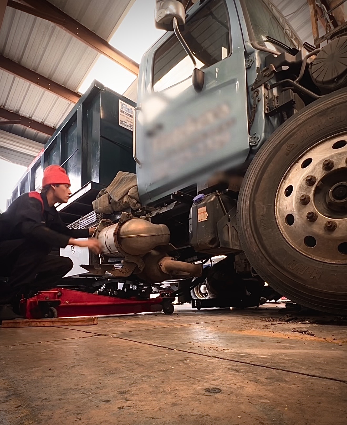 Jax Media Co founder working under a diesel truck in a shop
